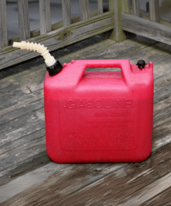 A red gas can sitting on top of a wooden deck.