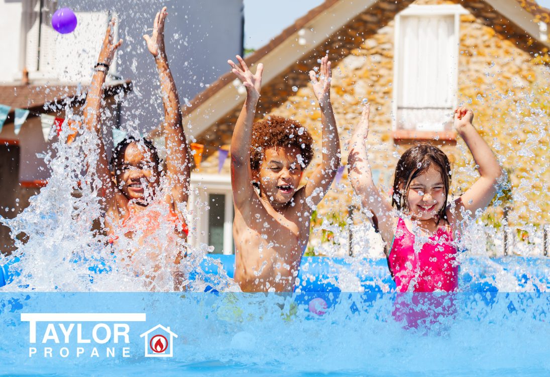 Three children playing in a pool with water splashing around them.