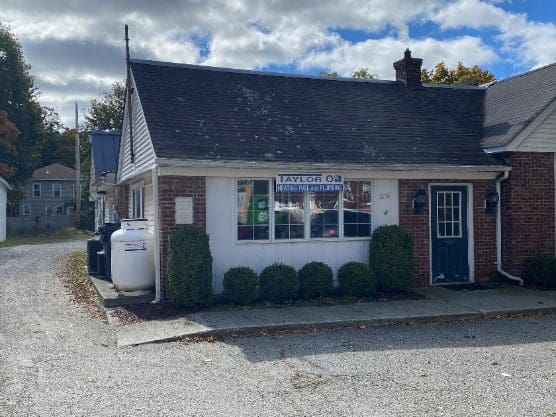 A small white building with a blue door and windows.