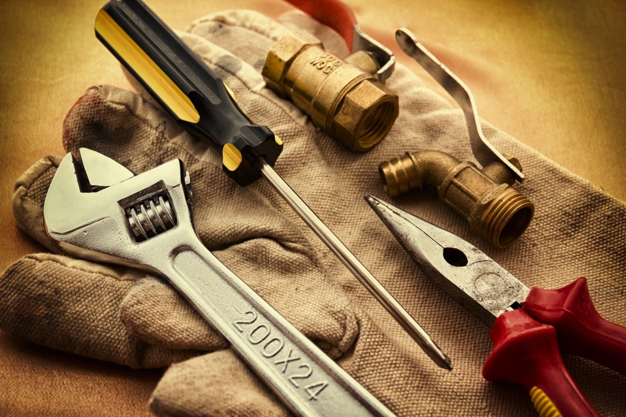 A pair of wrenches and other tools are sitting on the cloth.