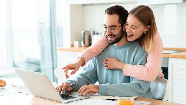 A man and woman are looking at the laptop.