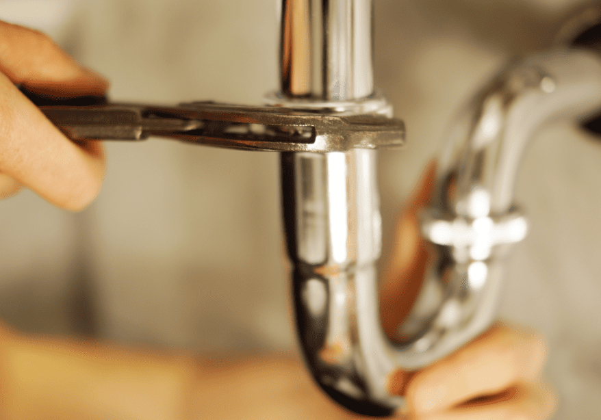 A person is fixing the faucet of a kitchen sink.